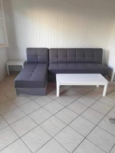 a blue couch and a white coffee table in a room at Alexandros Studios Apartments in Roda