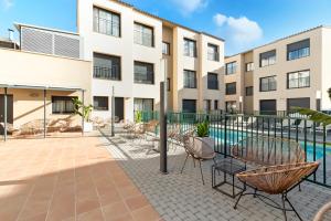 an apartment patio with chairs and a pool at Castell Beach Aparthotel in Castelldefels