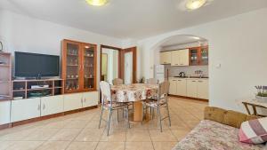 eine Küche und ein Esszimmer mit einem Tisch und einem TV in der Unterkunft Viola Two in Novigrad Istria