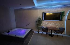 a room with a tub with a table and a tv at me and SPA in Düsseldorf