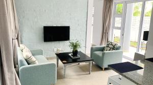 a living room with two chairs and a tv at Stay in Style in Durban