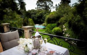 einen Tisch auf einem Balkon mit einem Tisch in der Unterkunft Fairlawns Boutique Hotel & Spa in Johannesburg