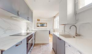 a white kitchen with white cabinets and a sink at CityStay-Confort- 5 min Metro - in Boulogne-Billancourt +9 photos