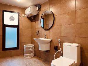 a bathroom with a toilet and a sink and a mirror at ONE Elegant Cottage near the Beach in Muscat
