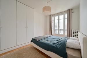 a bedroom with a bed and a window at CityStay-Confort- 5 min Metro - in Boulogne-Billancourt
