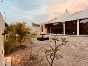 een huis met een binnenplaats met planten ervoor bij ONE Elegant Cottage near the Beach in Muscat