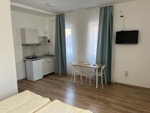 a room with a kitchen and a table with chairs at Smeštaj Milutinn, centar Sokobanje, iza Miloševog konaka in Soko Banja
