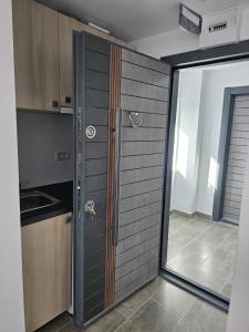 una cocina con una puerta corredera de cristal con fregadero en Zack Apartments, en Murfatlar