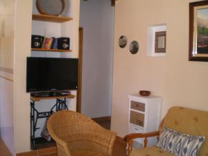 sala de estar con TV de pantalla plana y sillas en Casa 3-h, en Sant Francesc Xavier
