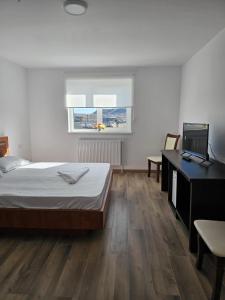 a bedroom with a bed and a desk with a laptop at Zack Apartments in Murfatlar