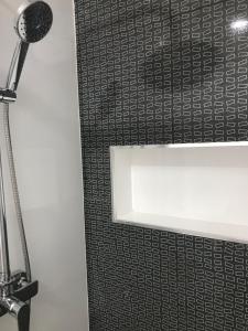 a bathroom with a black and white patterned wall at PrG Apartments in Praia
