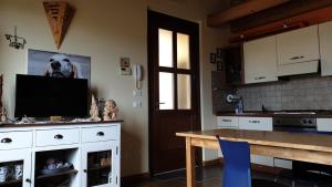 a kitchen with a table and a tv on a wall at Casa Francesca a 2,5 km da Iseo in Provaglio d'Iseo