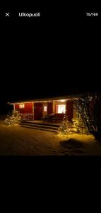 un edificio con luces de Navidad delante de él por la noche en Eco Countryside house by the Simo River & hottub en Simo