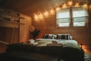 een slaapkamer met 2 handdoeken op een bed met een raam bij A magical get away with bath and forest view in Putten