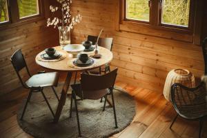 een houten eetkamer met een tafel en stoelen bij A magical get away with bath and forest view in Putten