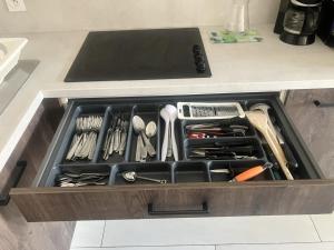 a drawer filled with utensils on a kitchen counter at maison entre plage marais et forêt in Olonne-sur-Mer