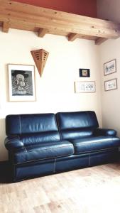 - un canapé en cuir bleu dans une pièce avec plafond dans l'établissement Casa Francesca a 2,5 km da Iseo, à Provaglio d'Iseo