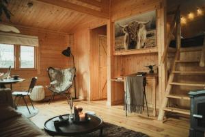 een woonkamer met een koeienfoto aan de muur bij A magical get away with bath and forest view in Putten