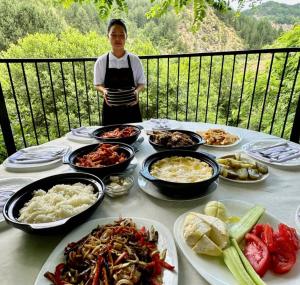 una mesa con muchos platos de comida. en Hotel SH & SH en Pukë