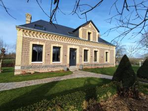 an old brick house with a driveway at Chez Mémère in Rolleville