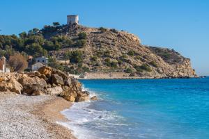a beach with a lighthouse on top of a hill at Tranquilidad a la Orilla del Mar in Villajoyosa