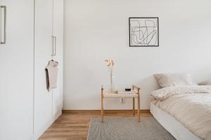 Dormitorio blanco con cama y mesa en New! City appartement with roof terrace! en Bergen