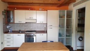 a kitchen with white cabinets and a wooden table at Casa Francesca a 2,5 km da Iseo in Provaglio d'Iseo +33 photos