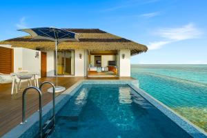 a villa with a swimming pool in the ocean at Pullman Maldives All-Inclusive Resort in Maamutaa