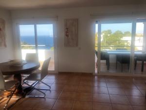 a dining room with a table and a view of the ocean at CASA ANA in Sant Josep de Sa Talaia