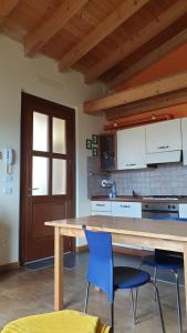 une cuisine avec une table en bois et deux chaises bleues dans l'établissement Casa Francesca a 2,5 km da Iseo, à Provaglio d'Iseo