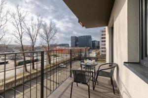a balcony with a table and chairs and a view of a city at Modern Apartment with Parking in Cracow by Rent like home in Kraków