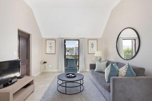 uma sala de estar com um sofá e uma televisão em Winelands Golf Lodges 21 em Stellenbosch
