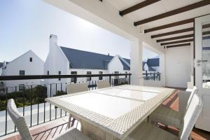 a patio with a table and chairs on a balcony at Winelands Golf Lodges 24 in Stellenbosch