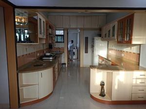 a kitchen with a person standing in the distance at gargi vill guest house in Pune