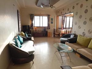 ein Wohnzimmer mit 2 Sofas und einem Glastisch in der Unterkunft gargi vill guest house in Pune