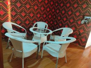 een glazen tafel en stoelen voor een muur bij Hotel Rose Garden - Janakpuri in New Delhi