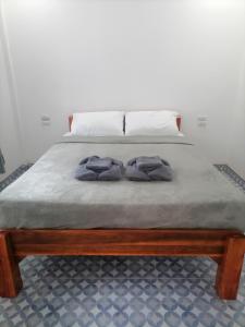 Una cama con dos almohadas encima. en Baan KaemSai en Khao Lak