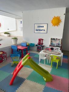 a play area with a slide in a room at Beachfront 3-bedroom apartment in Calafell