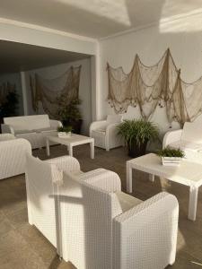 a room with white chairs and tables and curtains at Beachfront 3-bedroom apartment in Calafell