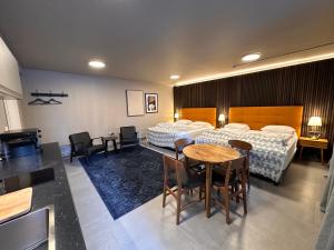 um quarto de hotel com duas camas e uma mesa e cadeiras em Travel Inn em Reykjavík