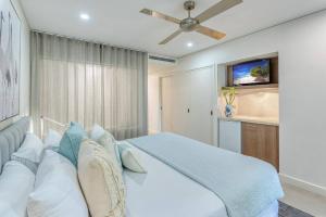 a bedroom with a large bed and a ceiling fan at 'Hibiscus Haven' Resort-style Chic by the Beach in Palm Cove