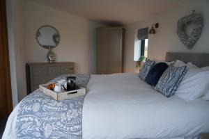 a bedroom with a white bed with a tray on it at The Angel - Luxury Lakeside Lodge in Cotham