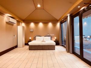 ONE Elegant Cottage near the Beach في مسقط: غرفة نوم كبيرة مع سرير وشرفة