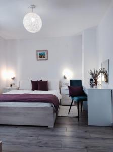 a white bedroom with a bed and a desk at Villa Iva in Rakovica