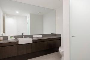 a bathroom with a sink and a toilet and a mirror at Swim-out Tropical Getaway by Four Mile Beach in Port Douglas +5 photos