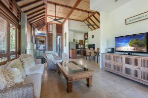 a living room with a large flat screen tv at Coco Villa - Central Mediterranean-style Pool Oasis in Port Douglas