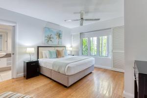 a white bedroom with a bed and a ceiling fan at In the Tropics Balcony Oasis at The Beach Club in Palm Cove +14 photos