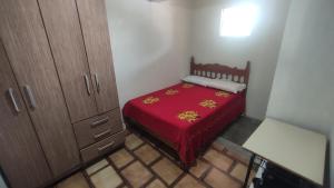 een kleine slaapkamer met een rood bed in een kamer bij Casa do Edivaldo in Rio de Contas