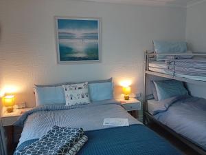 a bedroom with two bunk beds and two lamps at Sea Air B&B in Chapel Saint Leonards