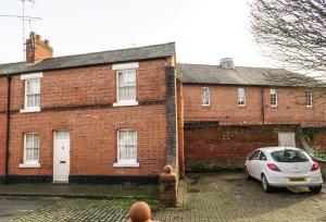 a car parked in front of a brick building at Chester Stays - Best Value Apartment with Free Parking in the heart of Chester in Chester